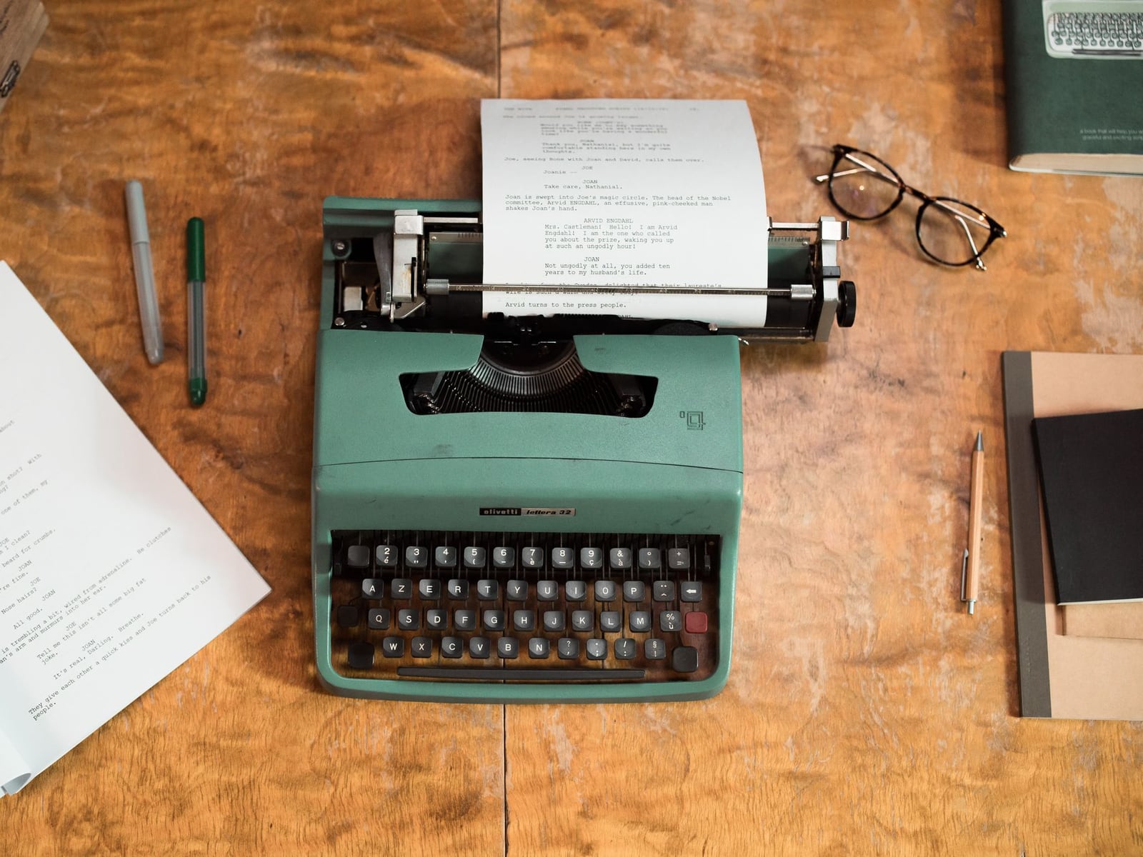 A printed video script and planning notes on a creative workspace table.